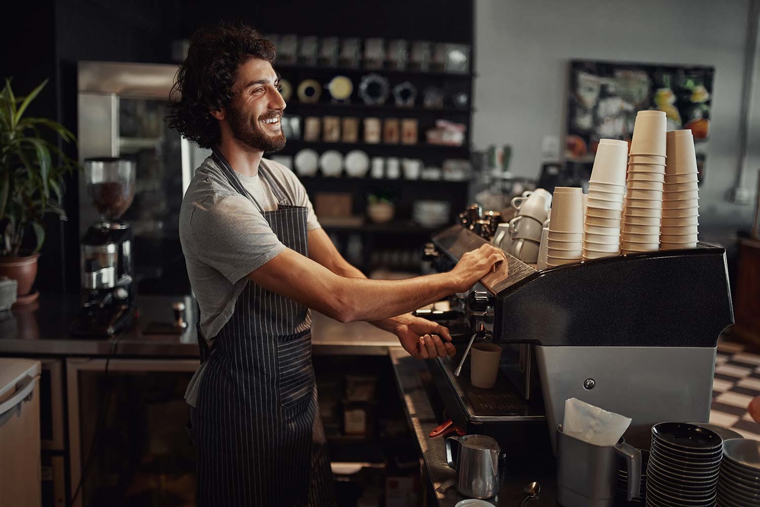 Técnico de Servimatic ofreciendo el servicio de atención técnica y reparando una máquina de café en un bar